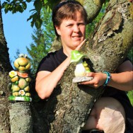 Foto: Frau mit Fröschen und einem Beutel am Bauch