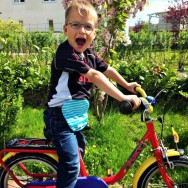 Foto: kleiner Radfahrer mit blauem Beutel am Bauch