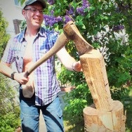 Foto: Stomaträger zeigt beim Holzhacken seinen Beutel am Bauch