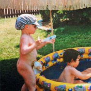 Foto: Kind mit Beutel am Bauch spielt im Sommer im Garten