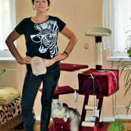 Foto: Stomaträgerin und ihre Katze, sie zeigt ihren Beutel am Bauch