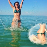 Foto: Stomaträgerin im Bikini tobt ausgelassen im Meer