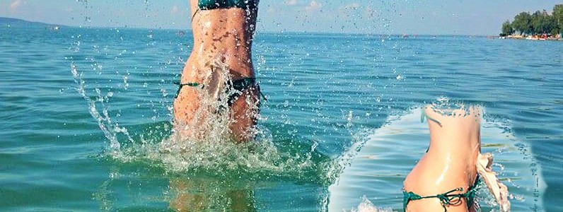 Foto: Stomaträgerin im Bikini tobt ausgelassen im Meer