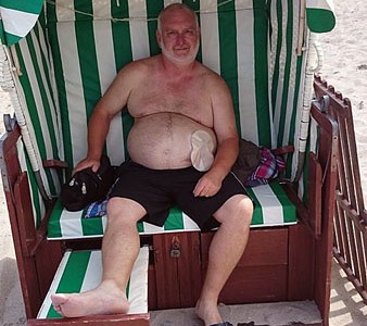 Foto: Stomaträger genießt seinen Urlaub im Strandkorb mit Stomabeutel am Bauch