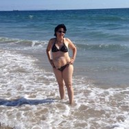 Foto: Stomaträgerin beim Baden im Meer, mit Stomabeutel am Bauch